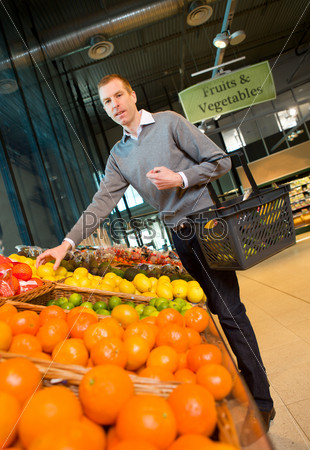 A man buying fresh fruits and vegetables at a grocery store
