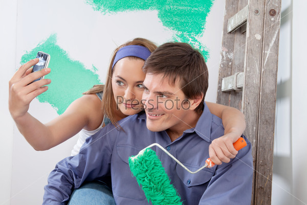 Молодая пара снимает себя на камеру во время ремонта квартиры