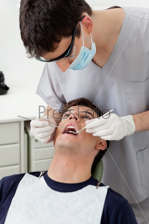 Dental hygienist working on patient\'s teeth
