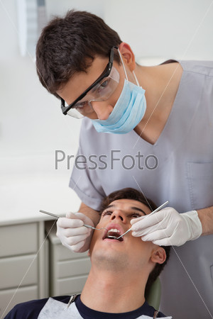 Dentist examining patient\'s teeth at clinic