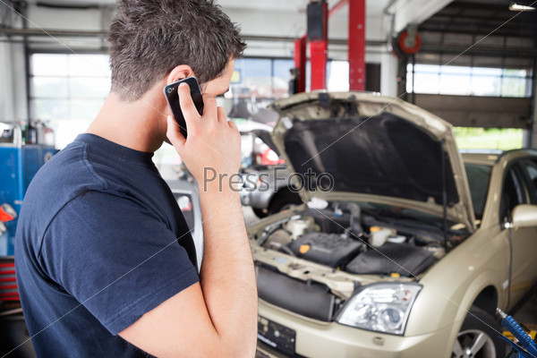 Mechanic talking on cell phone in garage