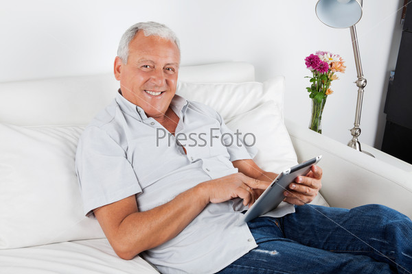 Portrait of smiling senior man using digital tablet PC