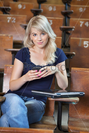 Portrait of young happy college girl sending a text message