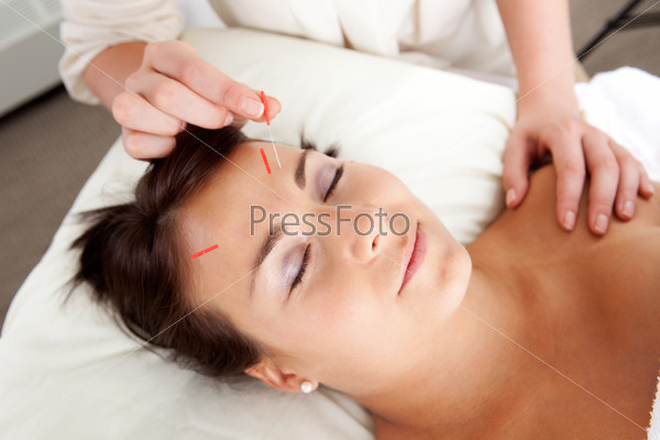 Needle being stimulated in face of young attractive patient