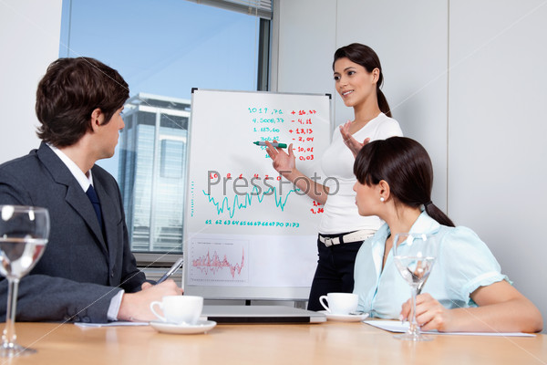 Business woman giving presentation to colleagues during meeting at office