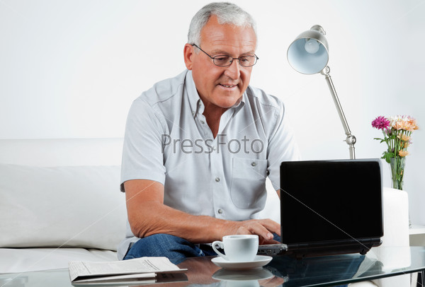 Senior man working on laptop at home