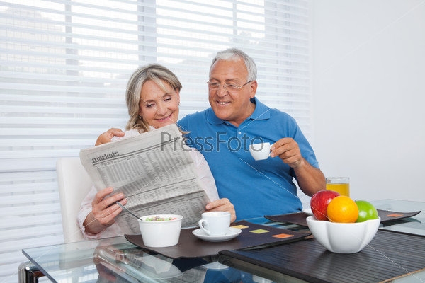 Пожилая пара читает газету