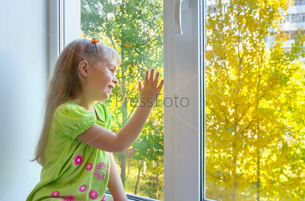 Cheerful girl sitting by the window