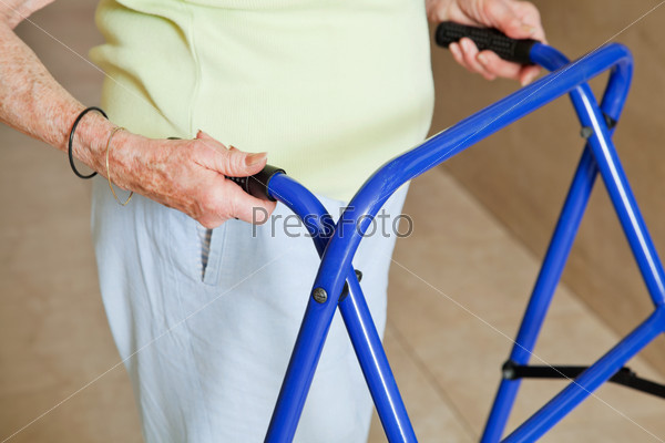 Старая женщина пользуется ходунками