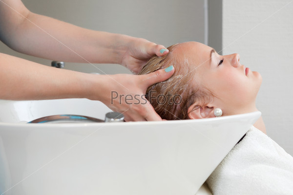 Side view of young woman getting her hair washed at the hairdresser