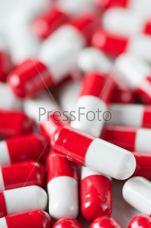 Vertical shot of red and white capsules, close-up
