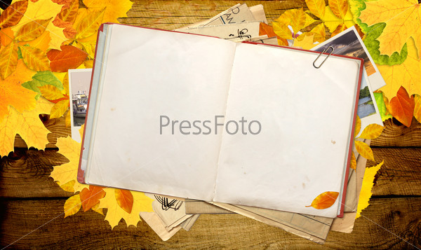 Old book, autumn leaves and photos. Objects over wooden planks