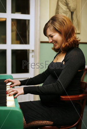 Pregnant woman plays on the piano