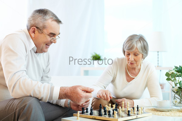 Portrait of senior couple playing chess at leisure