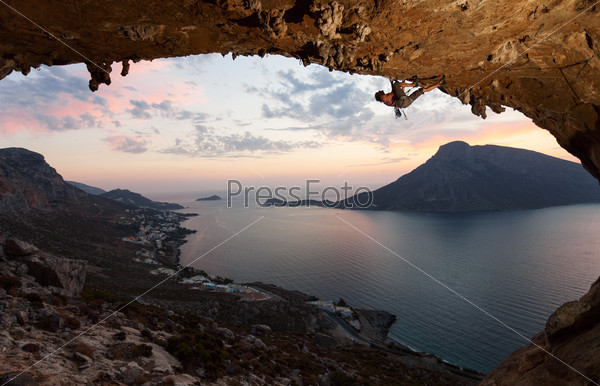 Silhouette of a rock climber against picturesque view of Telendos Island at sunset