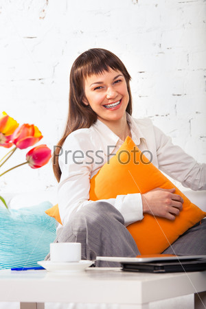 Young brunette woman with opened smile working at home