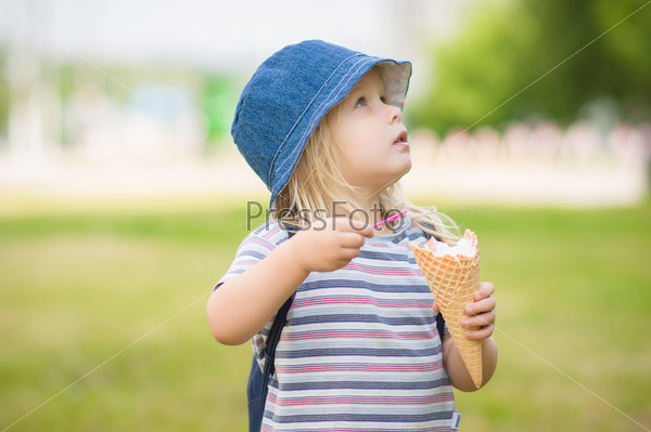 Adorable girl in blue hat eat ice cream