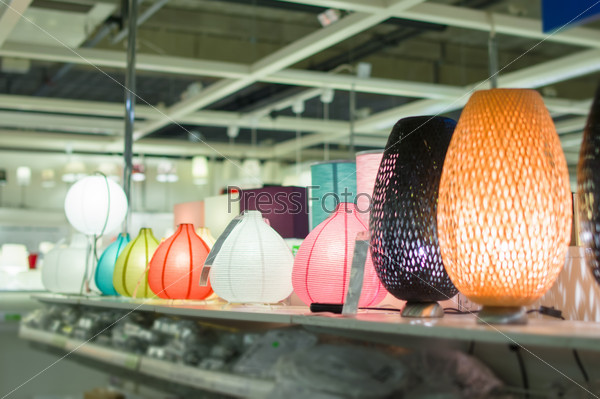 Variety of modern table  lamps on shelves in supermarket