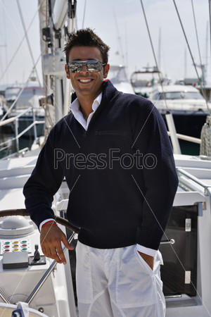Молодой мужчина в повседневной одежде на парусной лодке. Тоскана, Италия
