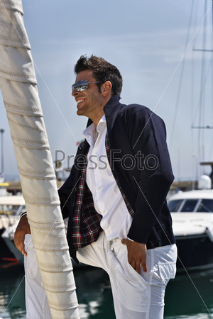 Италия, Тоскана, молодой моряк в повседневной одежде на парусной лодке