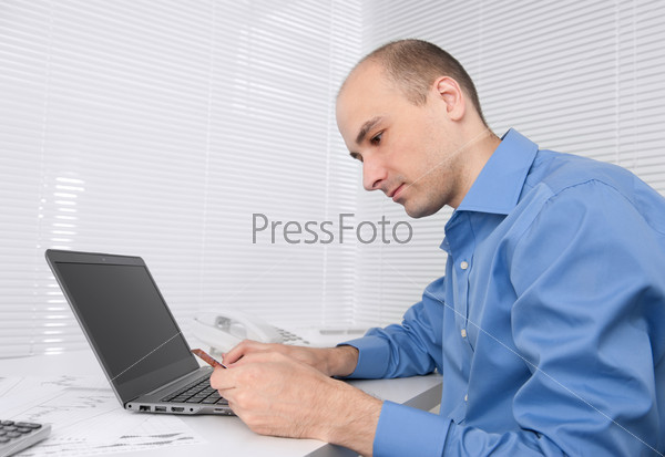 Handsome man holding credit card and using laptop for online shopping