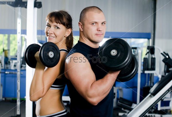 The woman with trainer in sports club