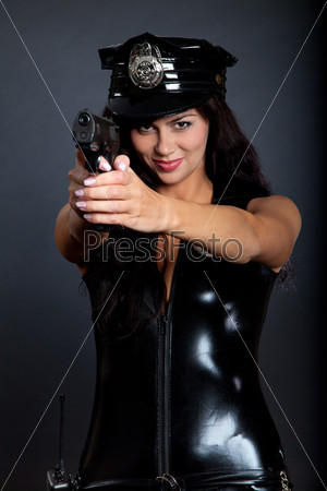 Красивая сексуальная девушка-полицейский с пистолетом и наручниками