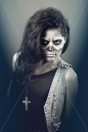 Young woman in day of the dead mask skull face art. Halloween face art with fog on black background