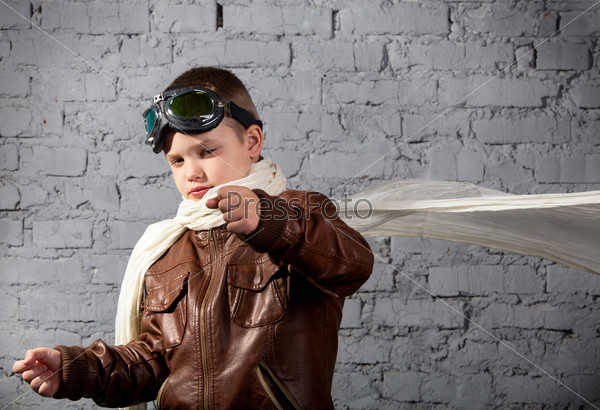 Little boy dreaming of becoming a pilot in retro style uniform