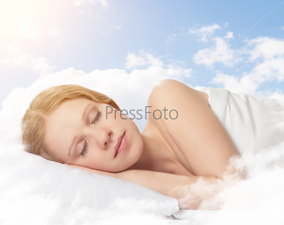 portrait of a beautiful young woman sleeping on a cloud in the sky
