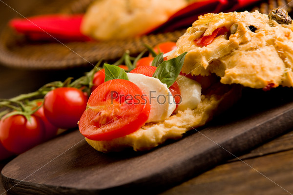 delicious homemade pizza rolls stuffed with tomatoes and mozzarella on wooden table