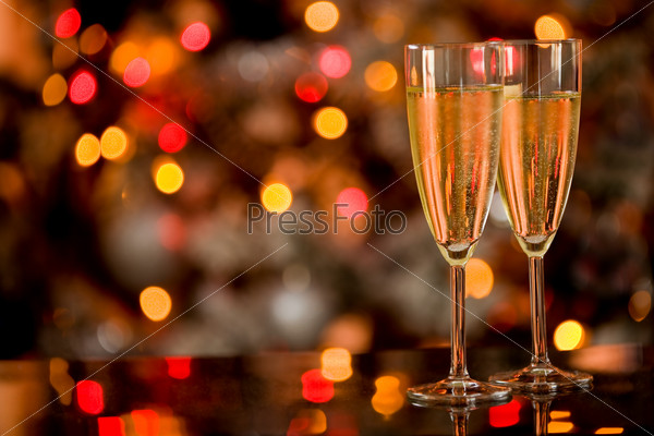 Шампанское на стеклянном столе на фоне размытых огней