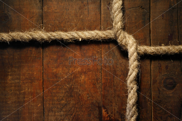Knotted hemp rope on dark wooden surface