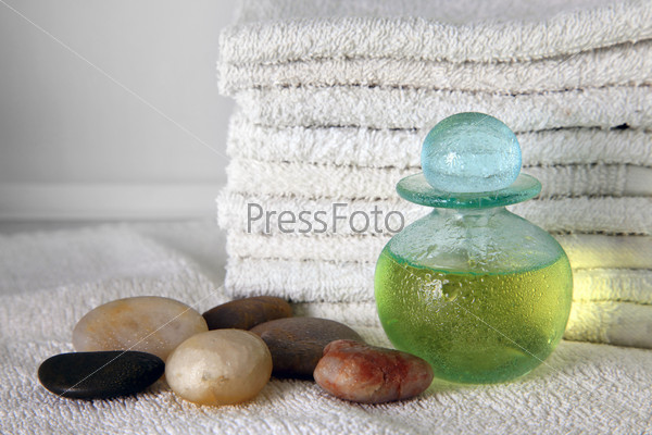 Blue bottle with massage oil on a background of towels, stock photo