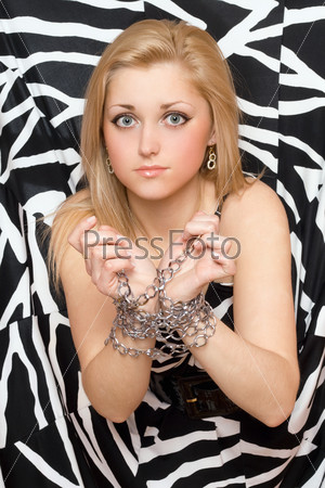 Pretty young woman stretches out her hands in chains