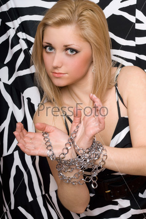 Attractive young woman stretches out her hands in chains