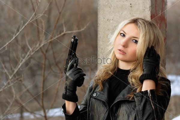 Confused blonde girl with weapon in her hands