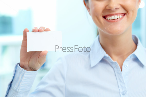 Close-up of blank card shown by young smiling businesswoman