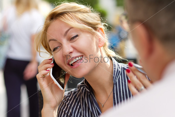 Young attractive businesswoman talking on the phone laughing