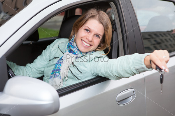 Happy smiling blond with ignition key showing in car window