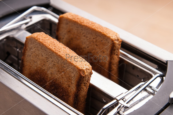 two hot bread toast in metal toaster