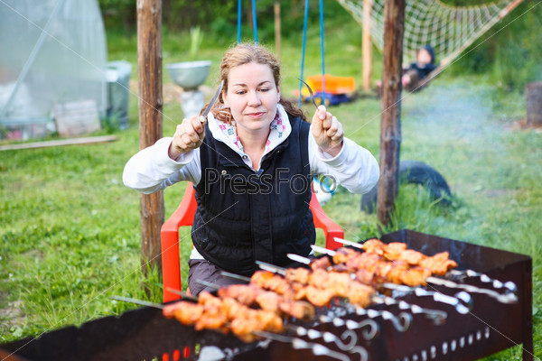 Hungry young female with fork and knife in hands sitting and waiting for grill meat