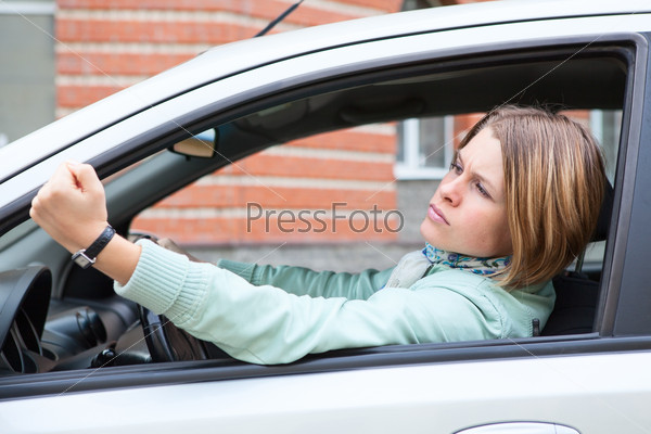 Young woman in car making some bad gestures