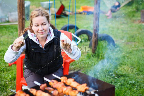 Hungry woman with fork and knife in hands sitting and waiting for grill meat. Copyspace