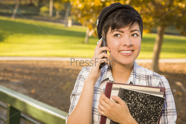 Smiling Mixed Race Female Student Holding Books and Talking on Phone