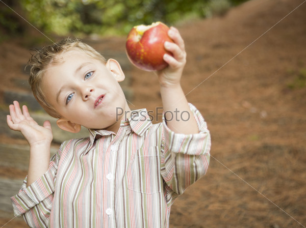 Adorable Child Boy Eating a Delicious Red Apple Outside.