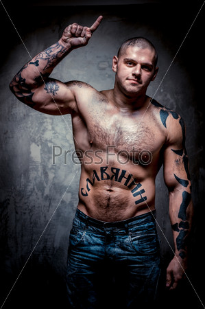 Muscular young man with many tattoos