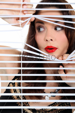 Woman spying through the blinds.