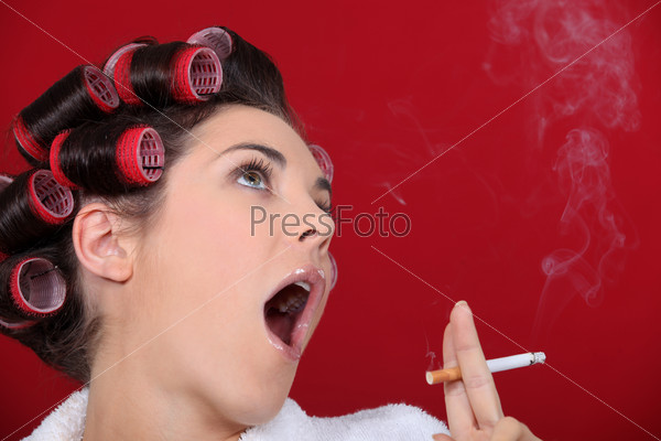Женщина с бигуди курит