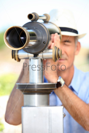 Middle-aged man looking through telescope